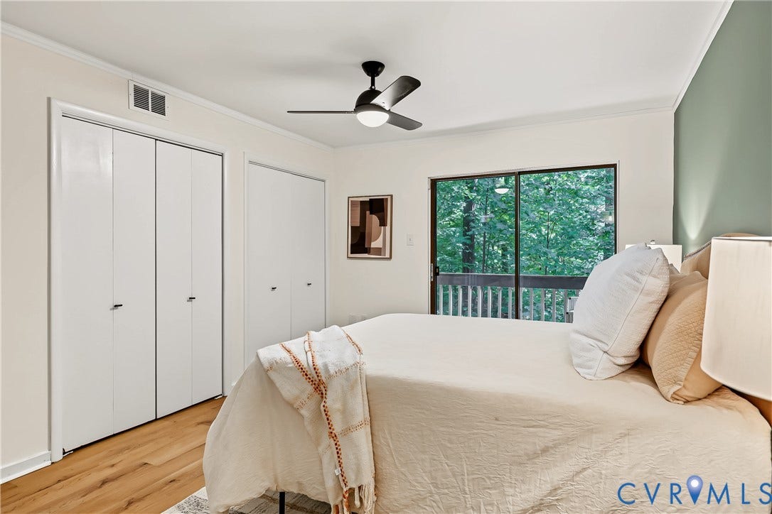 10272 Iron Mill Road, North Chesterfield, VA 23235 Room featuring wood-finish flooring, dual-door closets, a modern black ceiling fan, and sliding glass doors with exterior balcony access