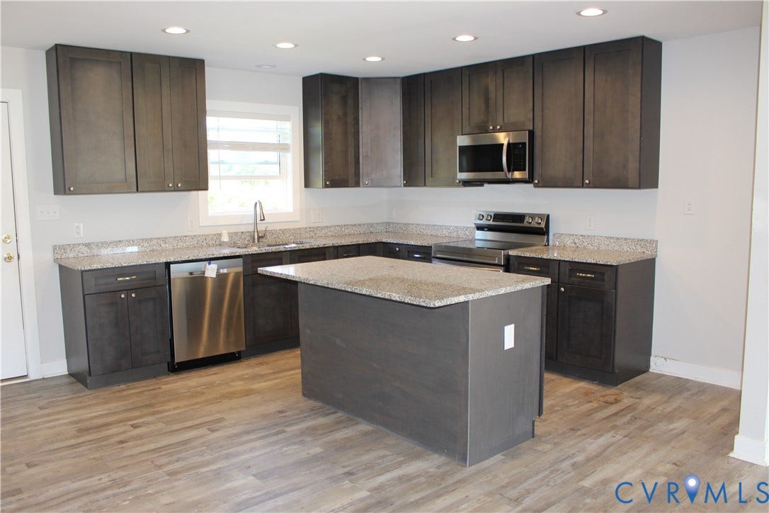 118 Clements Drive, Essex, VA 22560 Kitchen featuring charcoal-toned cabinetry, light-toned stone-finish countertops, a central island, recessed lighting, and stainless steel appliances