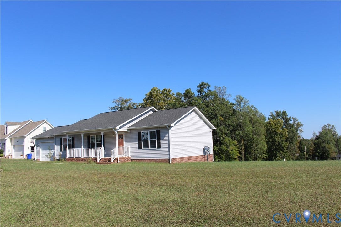 118 Clements Drive, Essex, VA 22560 Single-story residence featuring light-toned horizontal siding, a brick-veneer foundation, a covered front porch with white railing, and an attached garage
