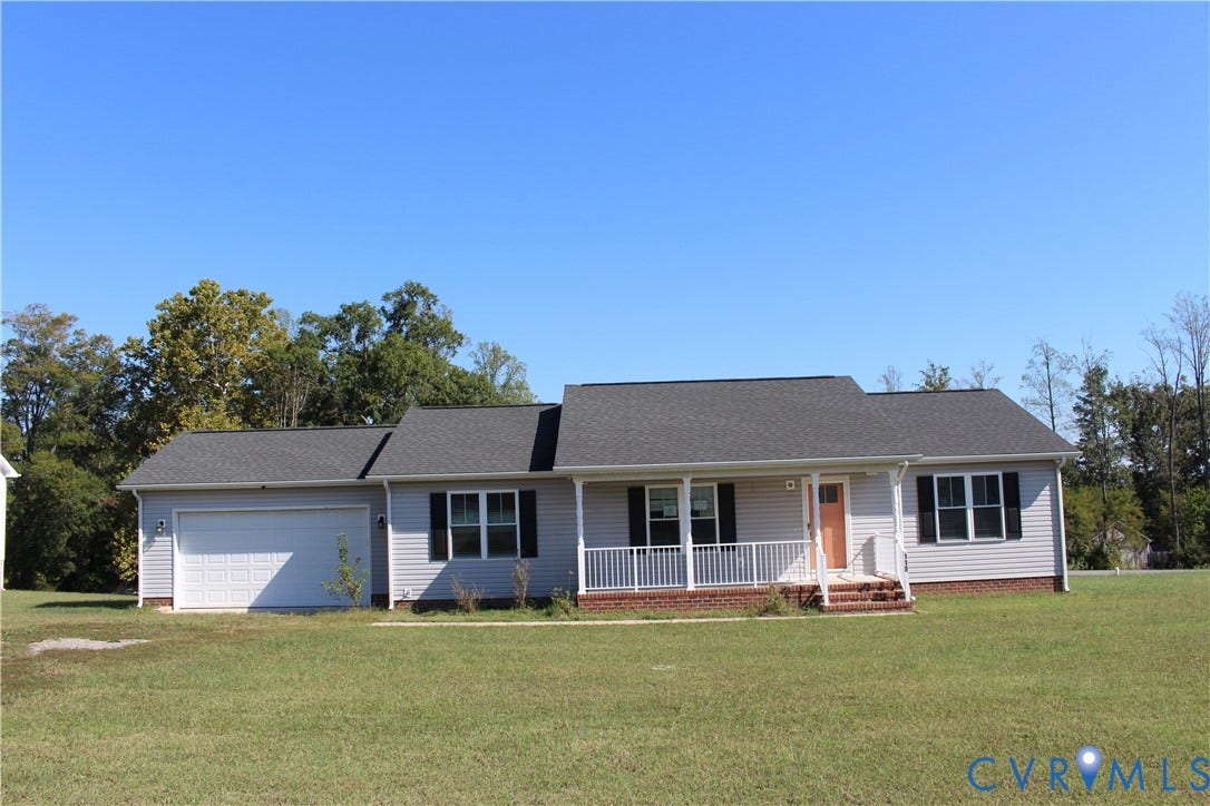 118 Clements Drive, Essex, VA 22560 Single-story residence featuring light gray siding, a brick foundation, a covered front porch with white railing, and an attached two-car garage