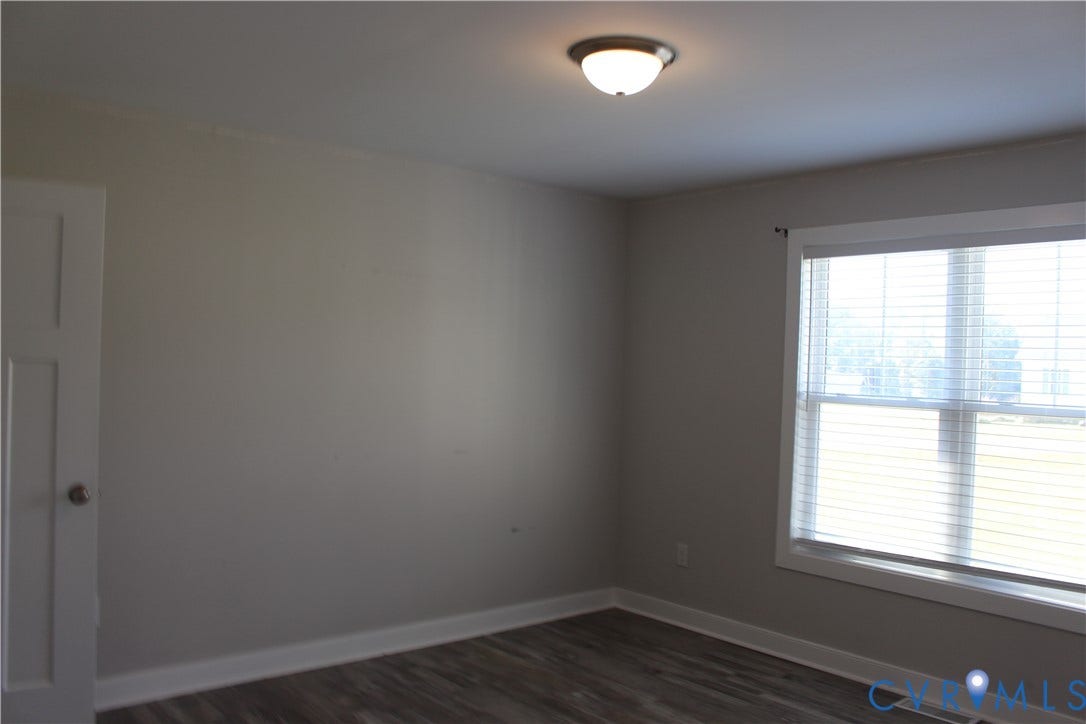 118 Clements Drive, Essex, VA 22560 Neutral-toned interior space featuring wood-finish flooring, a flush-mount ceiling light, and a multi-pane window with interior window blinds