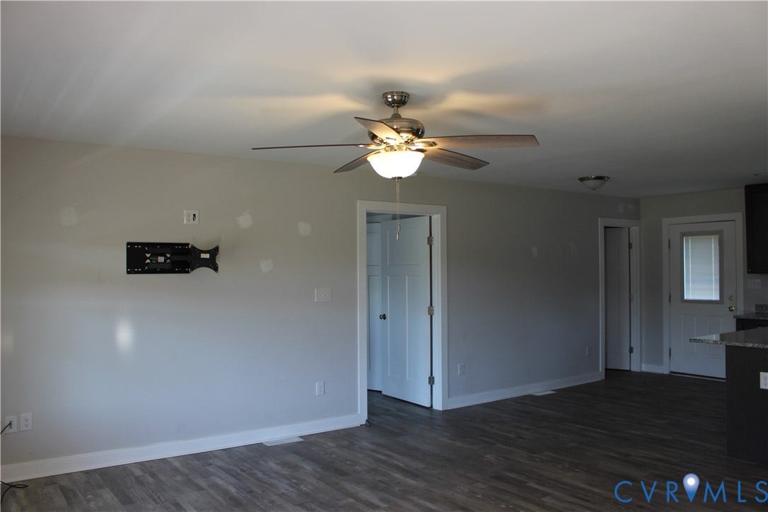 118 Clements Drive, Essex, VA 22560 Interior featuring wood-finish flooring, a brushed metal ceiling fan with integrated lighting, neutral wall paint, and a white six-panel door
