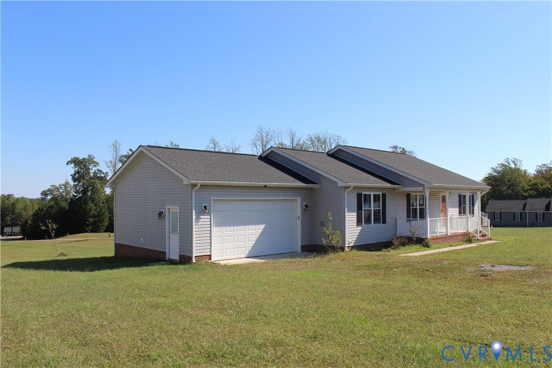 118 Clements Drive, Essex, VA 22560 Single-story residence featuring light-toned horizontal siding, a brick foundation veneer, an attached two-car garage, and a covered front porch with railing