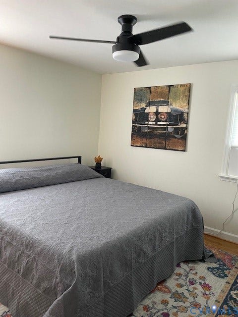 9005 Pine Hill Road, Hanover, VA 23116 Matte black ceiling fan with integrated lighting, wood-finish flooring, and natural light via single-pane window