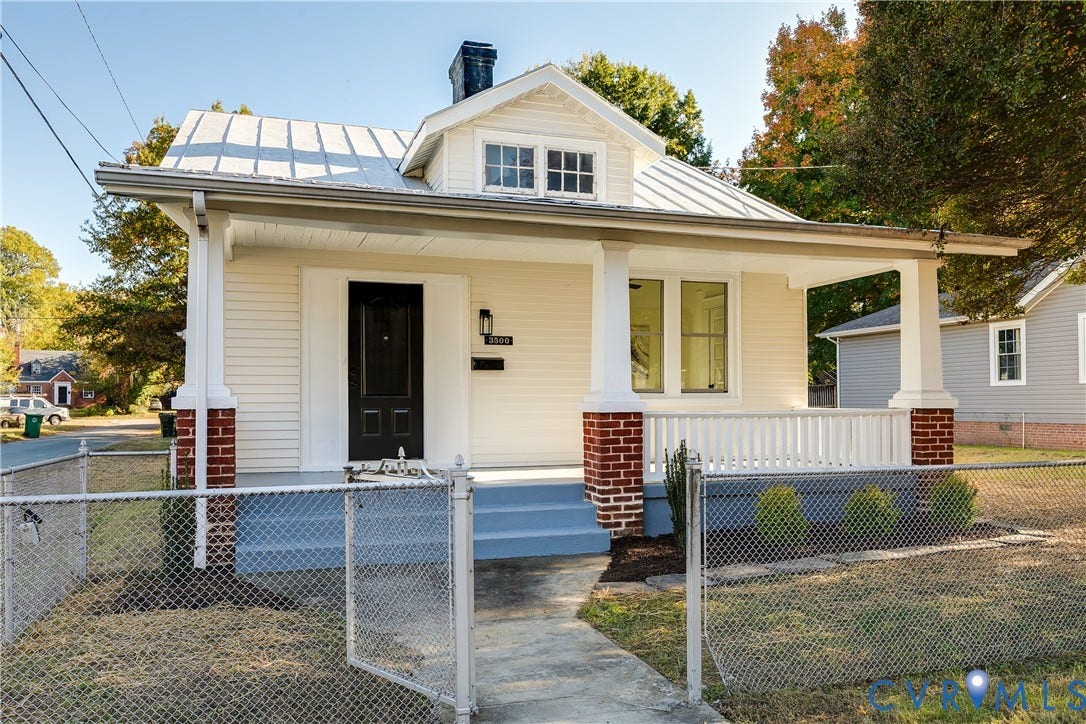 3500 Stockton Street, Weisigers Plan, Richmond, VA 23224 Single-story exterior featuring a metal roof, front porch with brick column bases, light-toned horizontal siding, and a centered dormer