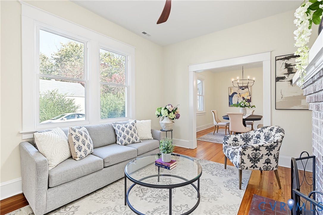 3500 Stockton Street, Weisigers Plan, Richmond, VA 23224 Living area featuring wood-finish flooring, tall windows with wide trim, and a brick fireplace surround