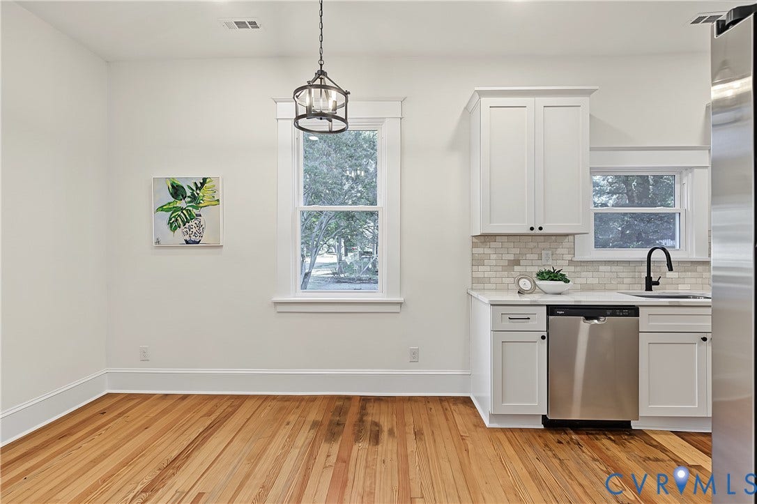 3500 Stockton Street, Weisigers Plan, Richmond, VA 23224 Kitchen area featuring wood-finish flooring, white shaker-style cabinetry, a brick-pattern tile backsplash, stainless steel dishwasher, and a matte black faucet