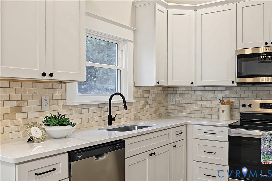 3500 Stockton Street, Weisigers Plan, Richmond, VA 23224 Kitchen featuring white shaker-style cabinetry, white solid-surface countertops, a stone tile backsplash, a stainless steel dishwasher, and a matte black gooseneck faucet