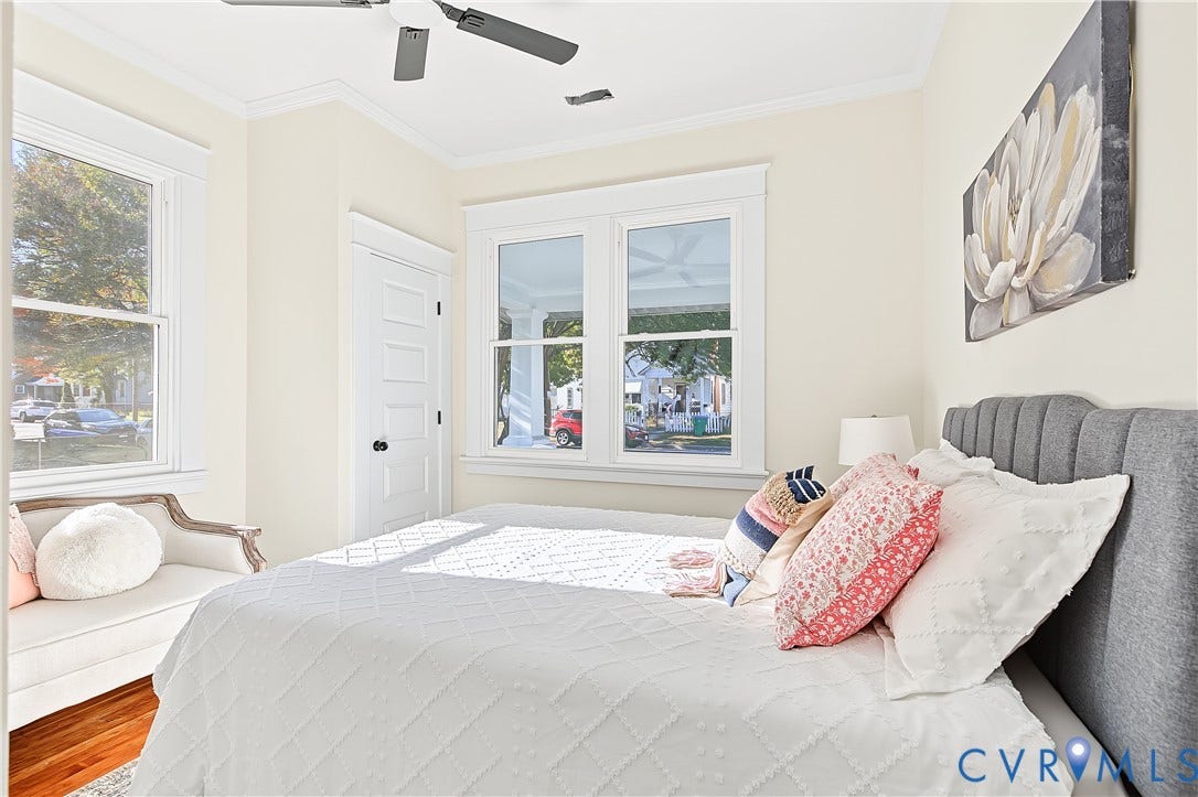 3500 Stockton Street, Weisigers Plan, Richmond, VA 23224 Bright room featuring wood-finish flooring, double-hung windows with substantial millwork trim, a four-panel interior door, and a ceiling-mounted fan