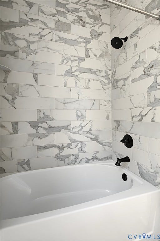 3500 Stockton Street, Weisigers Plan, Richmond, VA 23224 Full-height tub surround featuring rectified porcelain tile in a large-format running bond pattern, complemented by matte black hardware and a built-in soaking tub
