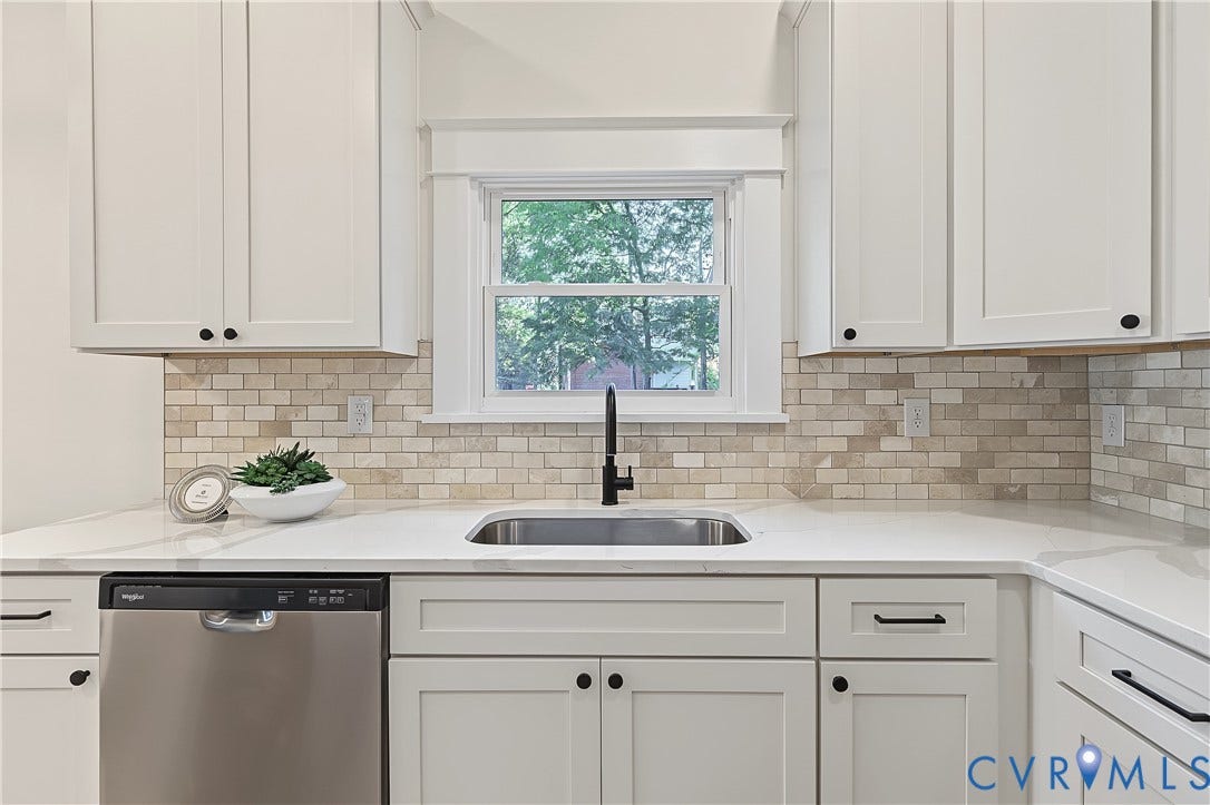 3500 Stockton Street, Weisigers Plan, Richmond, VA 23224 Kitchen featuring white shaker-style cabinetry, light-toned brick-patterned backsplash, stainless steel dishwasher, solid-surface countertop, and matte black plumbing fixtures
