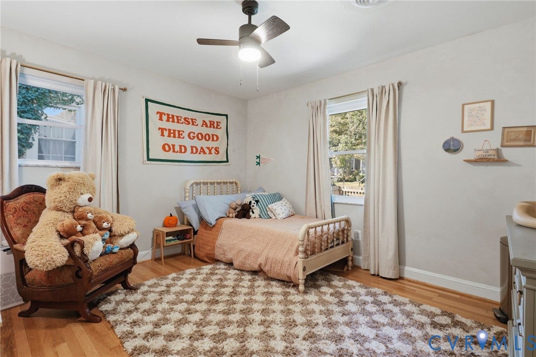 9 E 31st Street, Richmond, VA 23224 Room featuring wood-finish flooring, dual windows with natural light, and a ceiling-mounted light fixture with a multi-blade fan