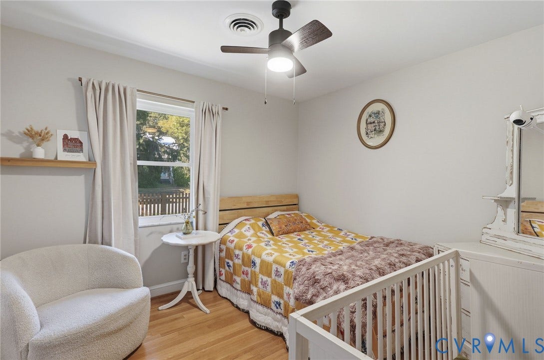 9 E 31st Street, Richmond, VA 23224 Room featuring wood-finish flooring, a wall-mounted floating shelf, and a ceiling fan with integrated lighting
