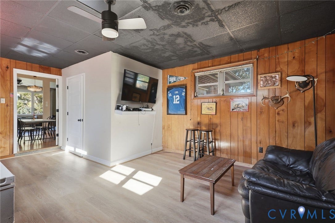 9 E 31st Street, Richmond, VA 23224 Wood-panelled wall cladding, wood-finish flooring, dark-toned drop ceiling, and an integrated ceiling fan with light fixture