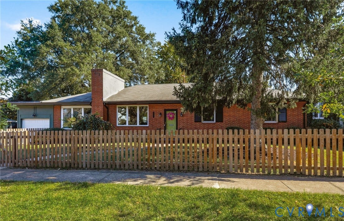 9 E 31st Street, Richmond, VA 23224 Single-story brick exterior featuring a prominent masonry chimney, attached garage, multi-pane windows, and a wood picket fence