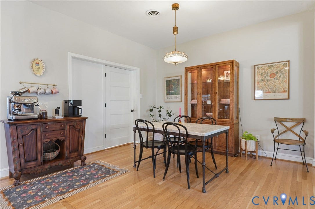 9 E 31st Street, Richmond, VA 23224 Dining area featuring wood-finish flooring, a tiered metal pendant light fixture, and a white five-panel interior door