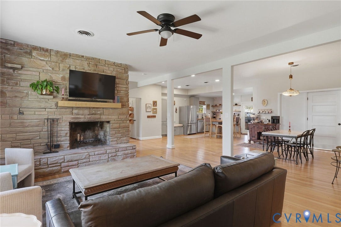 9 E 31st Street, Richmond, VA 23224 Floor-to-ceiling stone fireplace with a natural wood mantel, wood-finish flooring, recessed lighting, and a ceiling fan