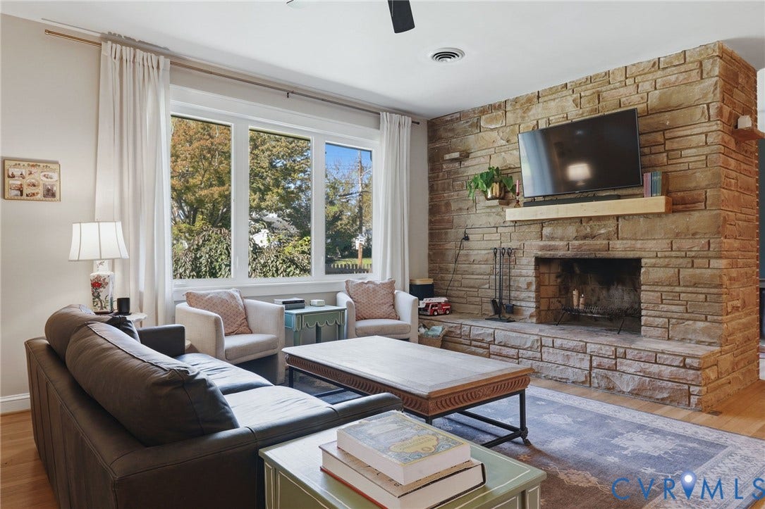 9 E 31st Street, Richmond, VA 23224 Floor-to-ceiling stone fireplace featuring a stone hearth and a natural wood mantel