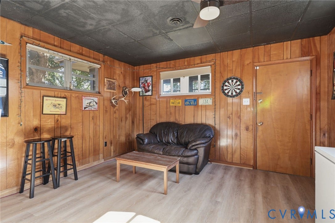 9 E 31st Street, Richmond, VA 23224 Wood-paneled wall surfaces, light wood-finish flooring, and a textured black ceiling featuring a flush-mount light fixture