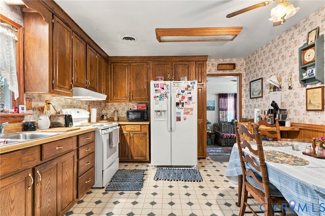 8840 Black Creek Road, New Kent, VA 23141 Kitchen featuring wood cabinetry, laminate countertops, a dual-basin stainless steel sink, built-in recessed ceiling lighting, and tile flooring