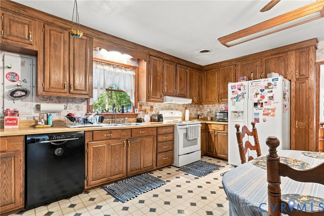 8840 Black Creek Road, New Kent, VA 23141 Kitchen featuring extensive wood cabinetry, solid surface countertops, and a double-basin stainless steel sink