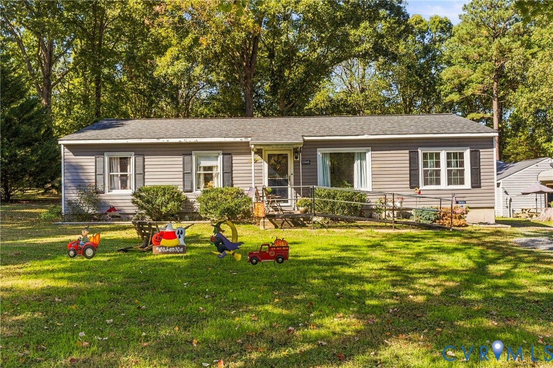 8840 Black Creek Road, New Kent, VA 23141 Ranch-style exterior with gray horizontal siding, dark decorative shutters, asphalt shingle roof, and a metal access ramp leading to the front entry