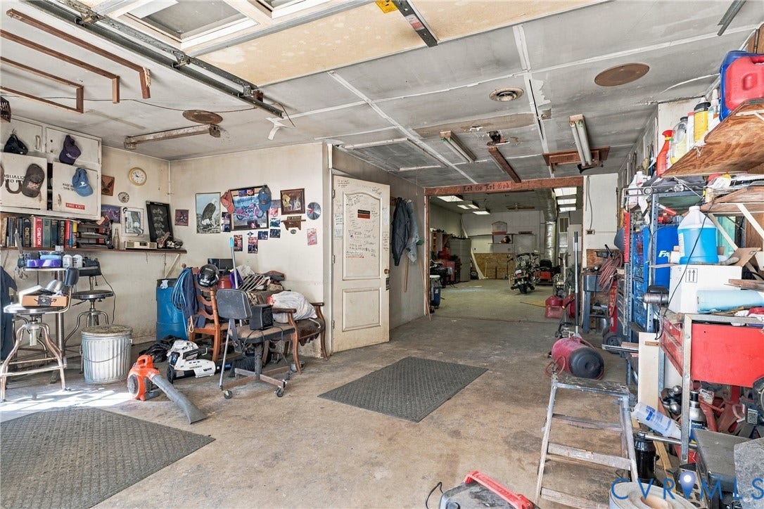 8840 Black Creek Road, New Kent, VA 23141 Expansive garage area featuring concrete flooring, integrated ceiling lighting, and a multi-section structural layout with a central pass-through door