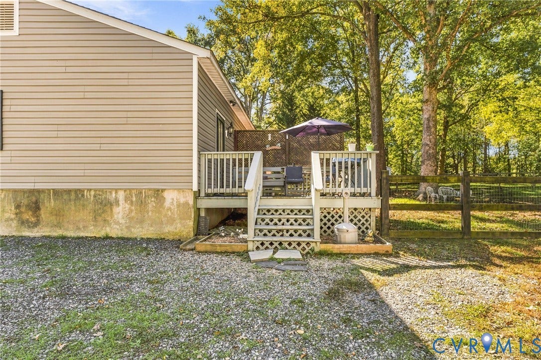 8840 Black Creek Road, New Kent, VA 23141 Raised wooden deck featuring lattice skirting, a privacy screen, and stairs with handrails