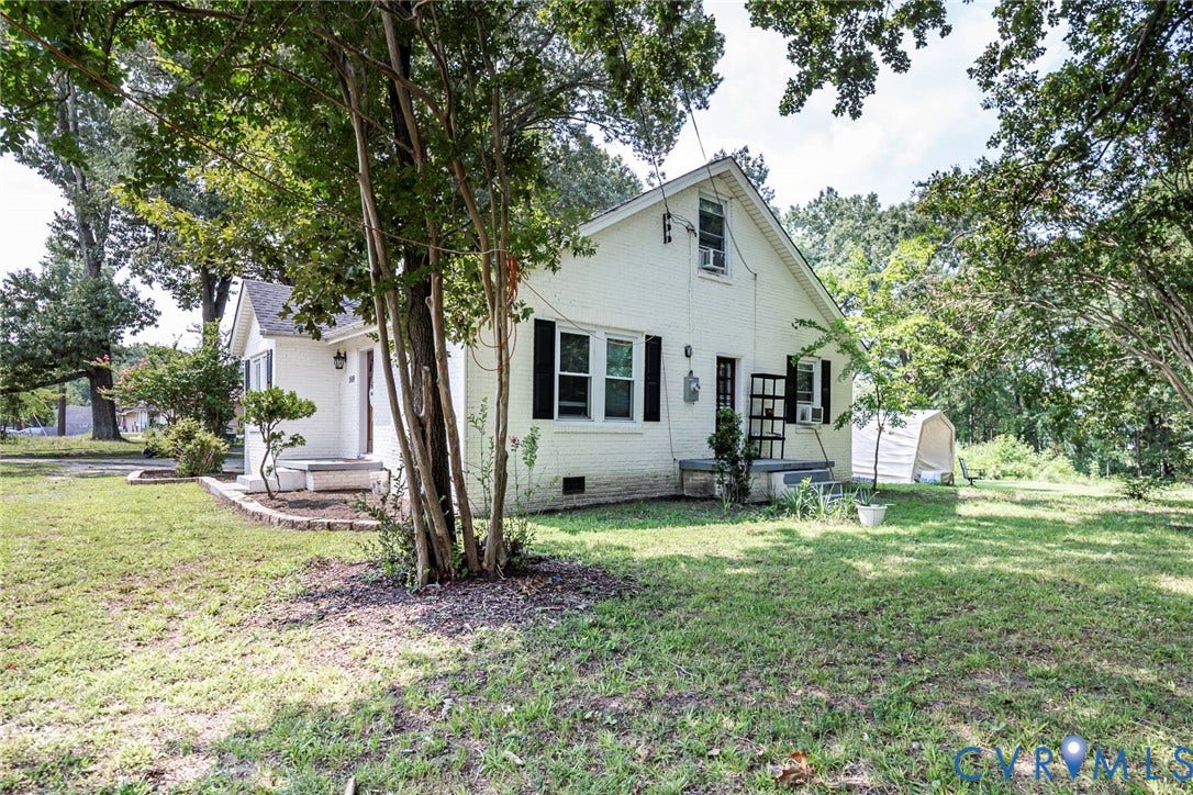 1818 Arlington Road, Hopewell, VA 23860 Painted brick exterior featuring dark shutters, gable roofline, and expansive grounds with mature trees