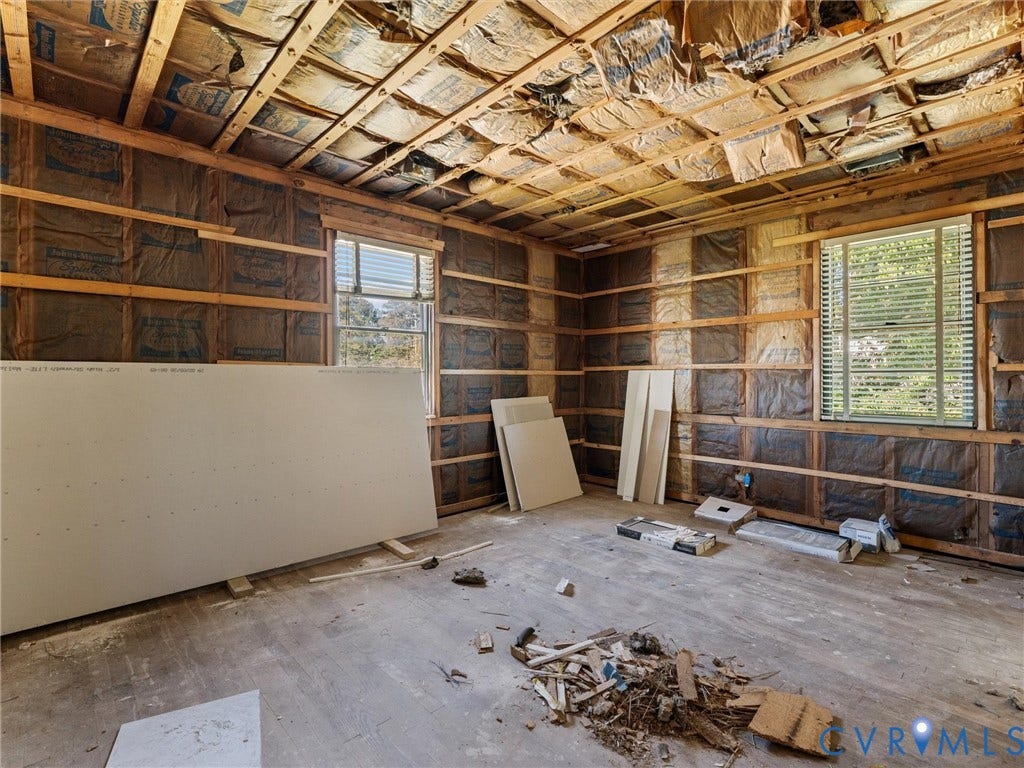 2900 Overton Road, Henrico, VA 23228 Interior space featuring exposed wood framing, batt insulation, two windows with horizontal blinds, and drywall panels