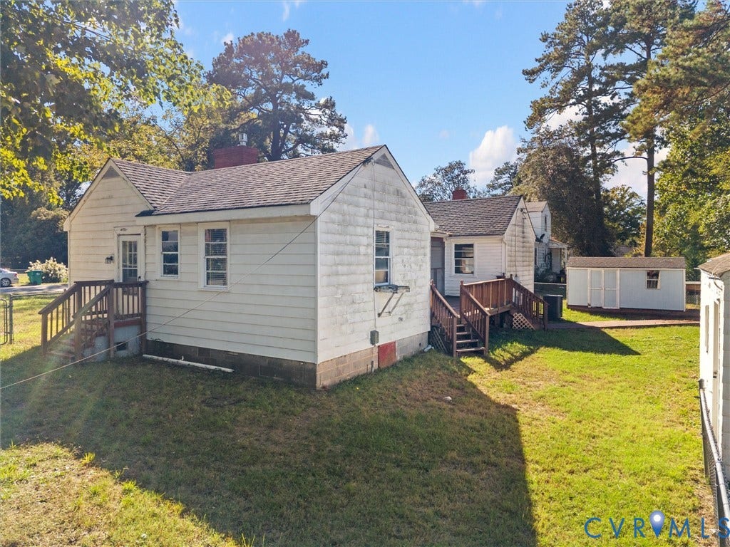 2900 Overton Road, Henrico, VA 23228 Exterior featuring horizontal siding, asphalt shingle roofing, two elevated wood decks, and a detached storage structure set on a grass-covered lot