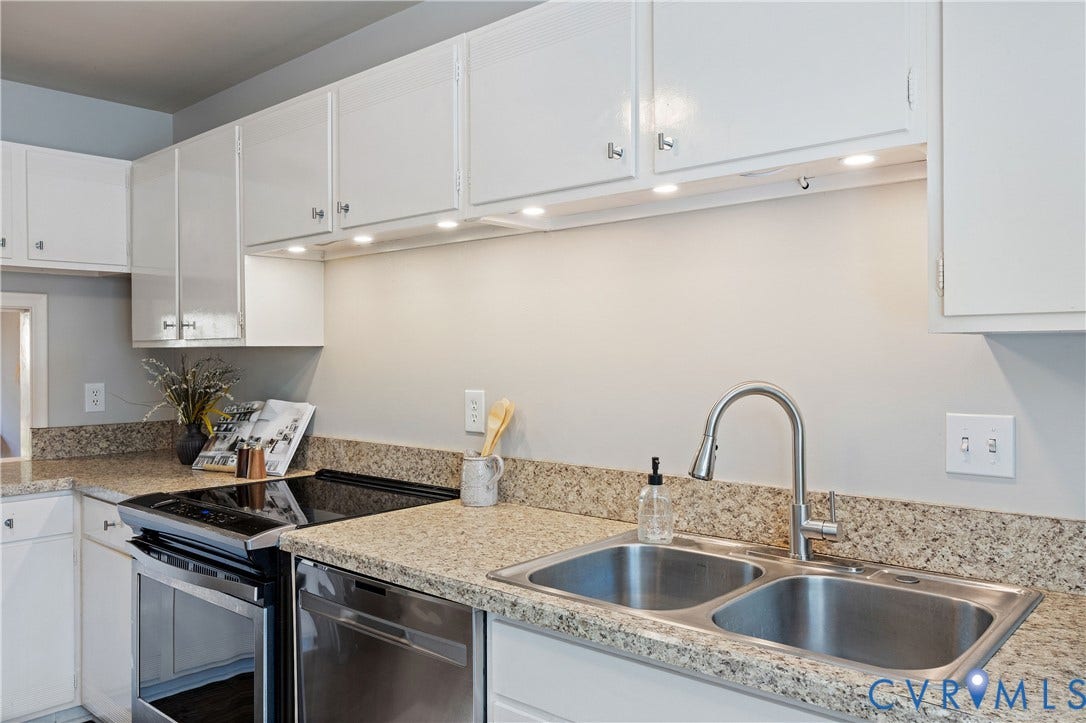 9131 Derbyshire Road, #B, Deerwood Condominiums, Henrico, VA 23229 Kitchen featuring white cabinetry, stone-finish countertops, stainless steel dual-basin sink with high-arc faucet, integrated under-cabinet lighting, and stainless steel appliances