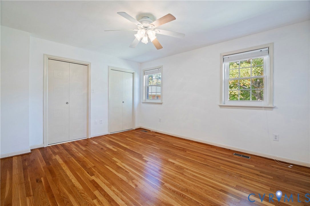 9131 Derbyshire Road, #B, Deerwood Condominiums, Henrico, VA 23229 Room featuring wood-finish flooring, dual closets with bi-fold doors, multi-pane windows, and a ceiling-mounted light fixture with fan
