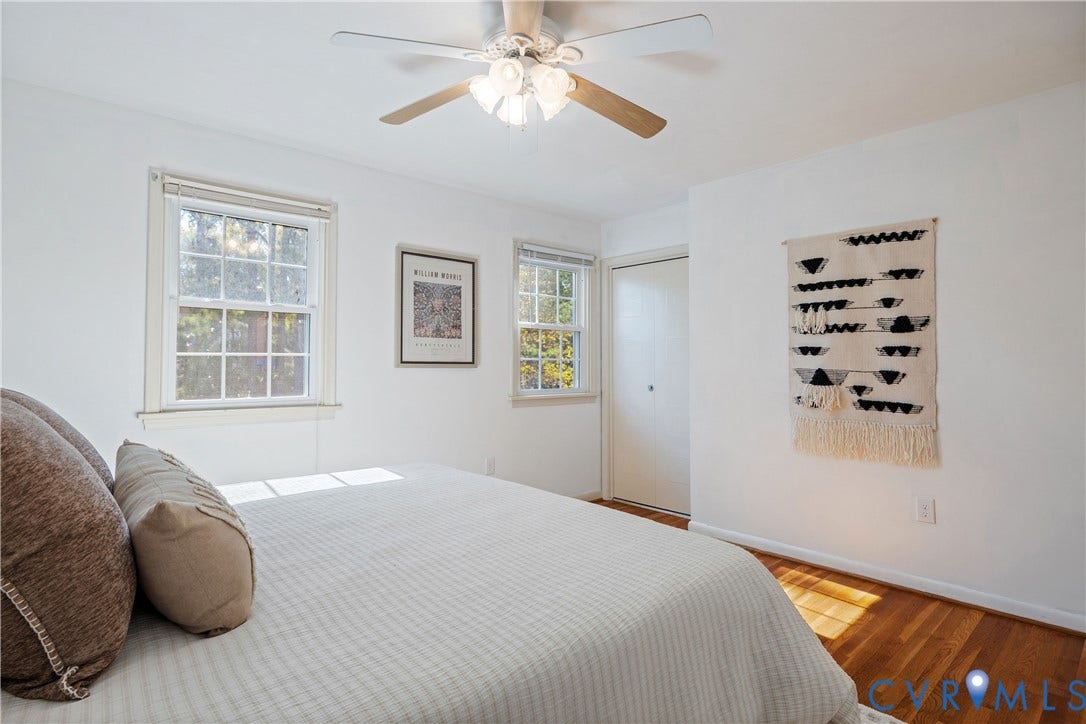 9131 Derbyshire Road, #B, Deerwood Condominiums, Henrico, VA 23229 Neutral interior featuring wood-finish flooring, double-hung windows, and a ceiling fan with integrated light fixture