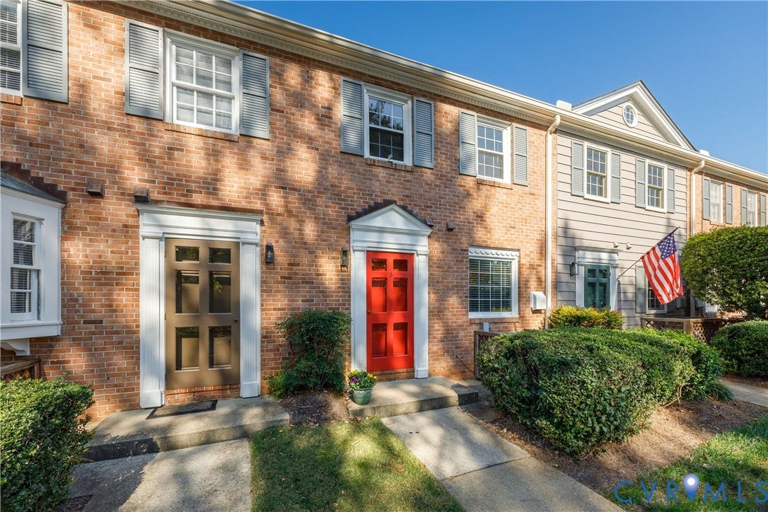 9131 Derbyshire Road, #B, Deerwood Condominiums, Henrico, VA 23229 Classic brick townhouse exterior featuring multi-pane windows, louvered shutters, decorative door surrounds, and dual-entry design