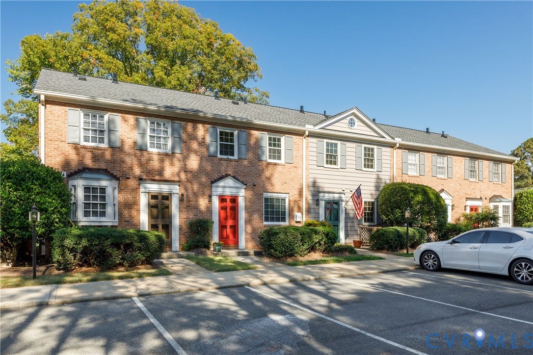 9131 Derbyshire Road, #B, Deerwood Condominiums, Henrico, VA 23229 Multi-unit residential exterior featuring a classic brick and horizontal siding faade, multi-pane windows with decorative shutters, pedimented entryways, and asphalt shingle roofing