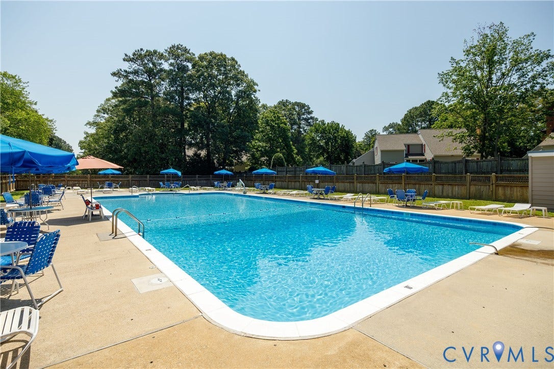9131 Derbyshire Road, #B, Deerwood Condominiums, Henrico, VA 23229 Rectangular outdoor swimming pool featuring a concrete deck, metal pool ladder, and perimeter fencing