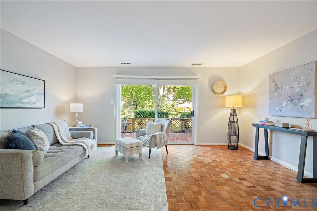 9131 Derbyshire Road, #B, Deerwood Condominiums, Henrico, VA 23229 Living area featuring parquet wood-finish flooring and large sliding glass doors opening to a brick patio