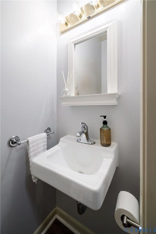 9131 Derbyshire Road, #B, Deerwood Condominiums, Henrico, VA 23229 Wall-mounted porcelain sink with polished chrome faucet, framed mirror with integrated ledge, and polished chrome hardware