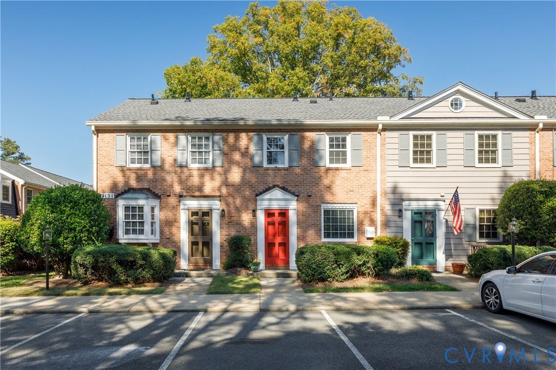 9131 Derbyshire Road, #B, Deerwood Condominiums, Henrico, VA 23229 Brick and horizontal siding exterior featuring a gabled roofline, multi-pane windows, and individual entry doors with colonial-style trim