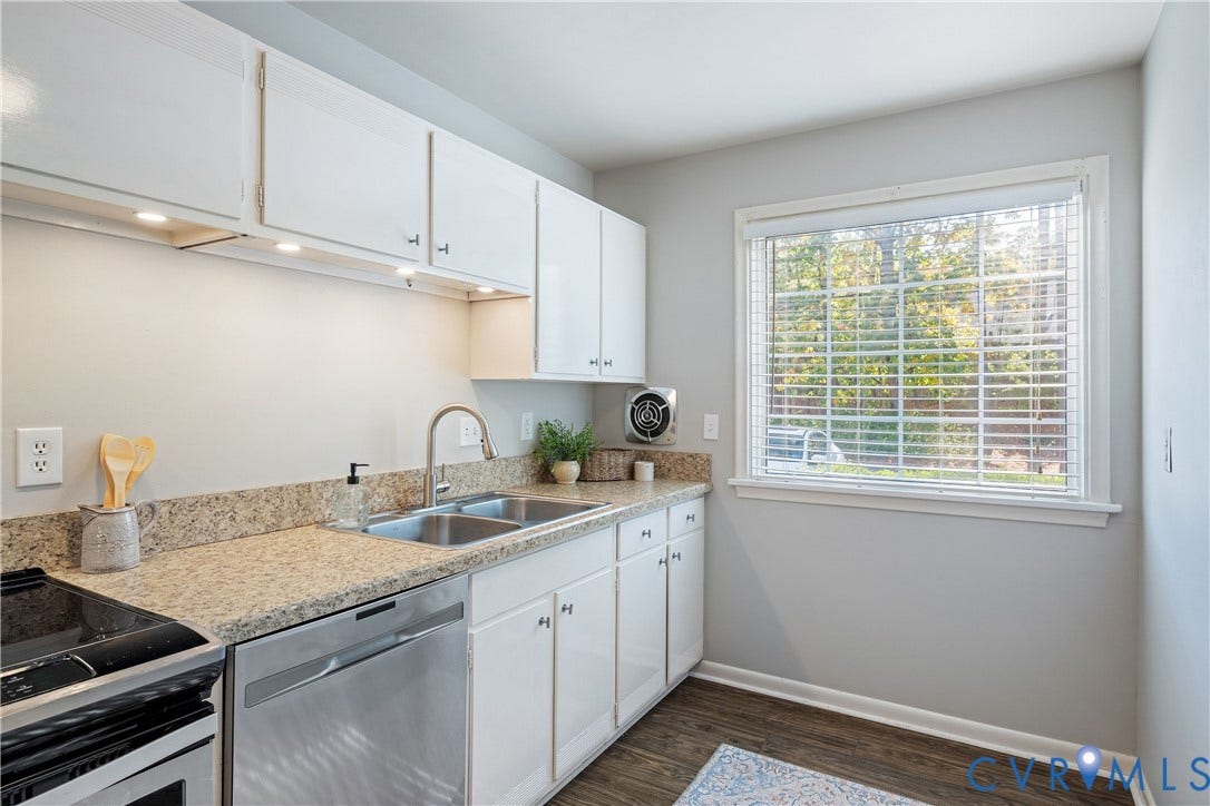 9131 Derbyshire Road, #B, Deerwood Condominiums, Henrico, VA 23229 Kitchen featuring white cabinetry, stone-finish countertops, stainless steel dual-basin sink with arched faucet, and wood-finish flooring