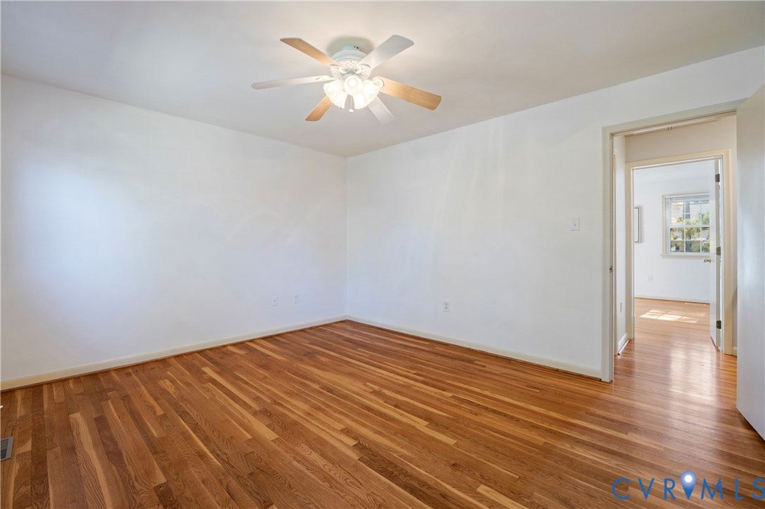 9131 Derbyshire Road, #B, Deerwood Condominiums, Henrico, VA 23229 Room featuring wood-finish flooring, white walls, and a ceiling-mounted light fixture with a fan