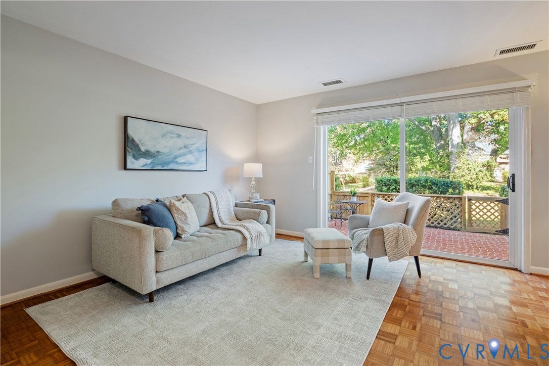 9131 Derbyshire Road, #B, Deerwood Condominiums, Henrico, VA 23229 Parquet wood-finish flooring, neutral wall tones, and floor-to-ceiling sliding glass doors opening to a brick-paved patio