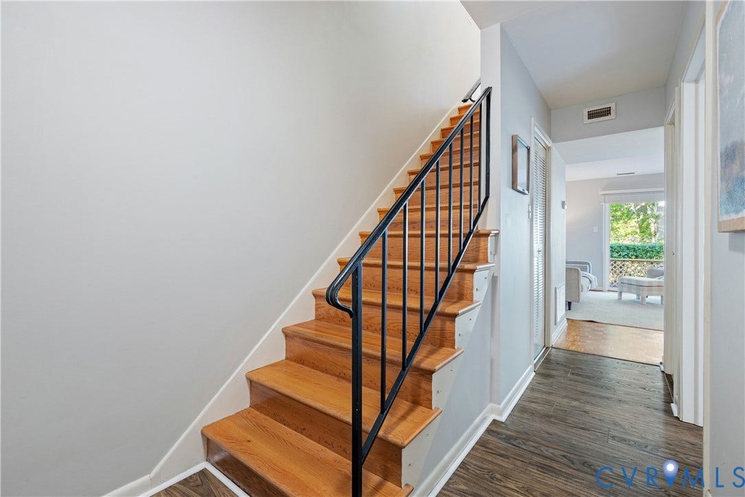 9131 Derbyshire Road, #B, Deerwood Condominiums, Henrico, VA 23229 Staircase featuring wood treads and a black metal railing, complemented by wood-finish flooring