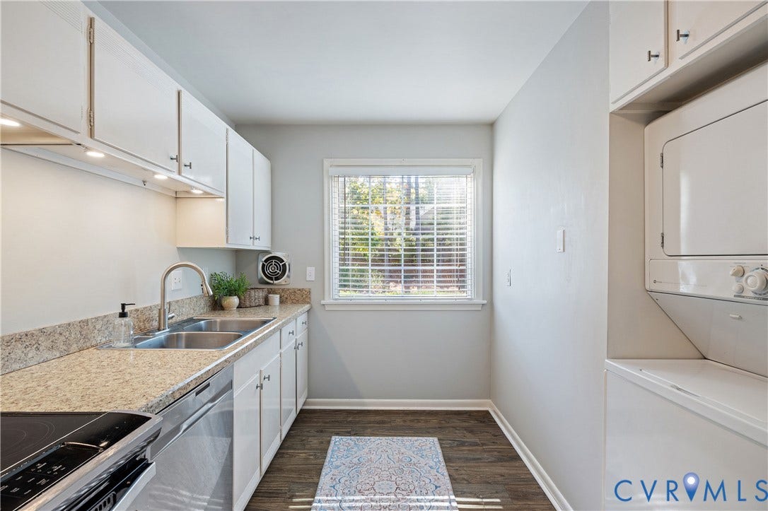 9131 Derbyshire Road, #B, Deerwood Condominiums, Henrico, VA 23229 Utility room featuring white cabinetry, stone-finish countertops, stainless steel dual-basin sink, wood-finish flooring, and stacked laundry unit