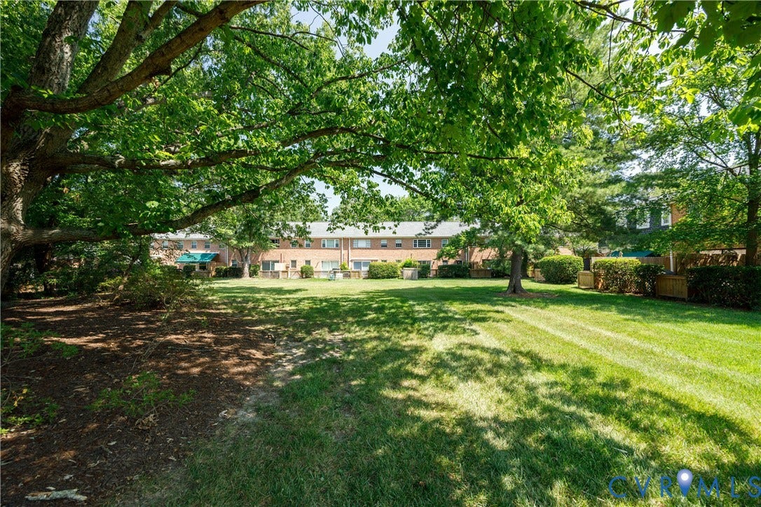 9131 Derbyshire Road, #B, Deerwood Condominiums, Henrico, VA 23229 Expansive lawn area featuring mature trees, landscaped shrubbery, and brick building exteriors