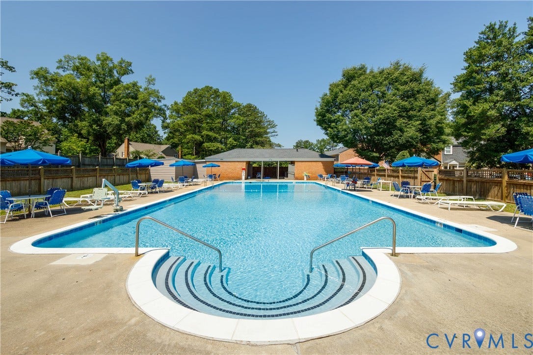 9131 Derbyshire Road, #B, Deerwood Condominiums, Henrico, VA 23229 Rectangular outdoor swimming pool featuring a curved walk-in staircase with stainless steel handrails, concrete decking, and a brick-facade pool house