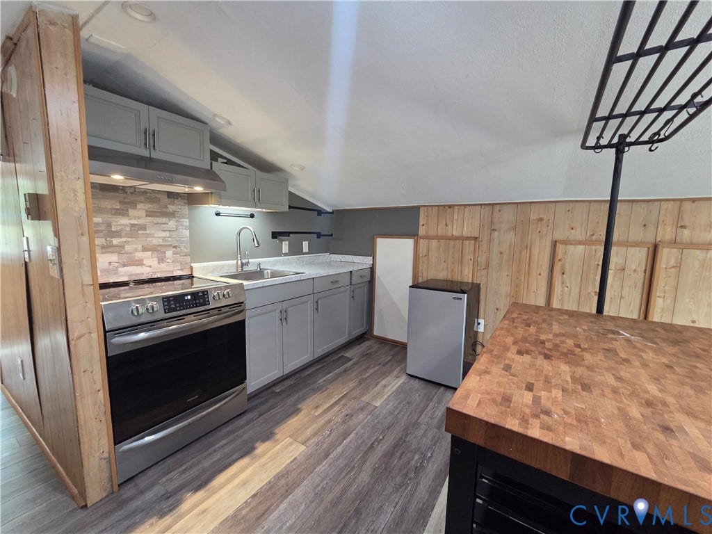 7620 Cypress Drive, Lanexa, VA 23089 Kitchen featuring light gray cabinetry, stainless steel range, stone-tiled backsplash, butcher-block countertop, and wood-finish flooring