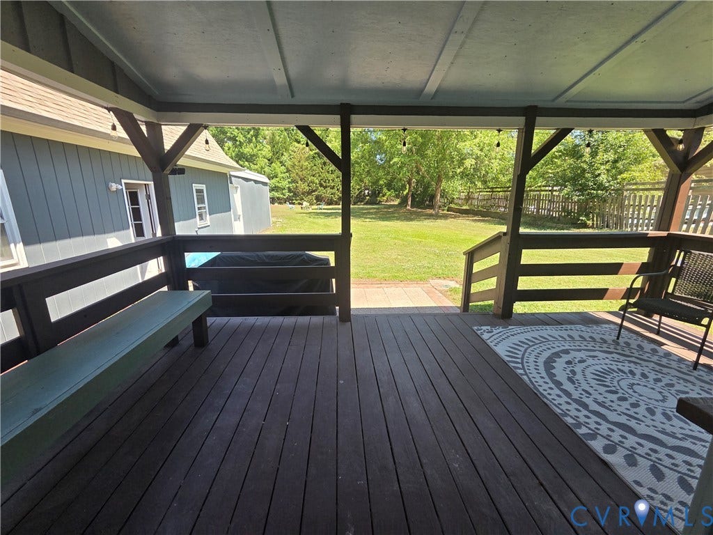 7620 Cypress Drive, Lanexa, VA 23089 Covered wooden deck featuring a built-in bench, railing, and direct access to the rear yard