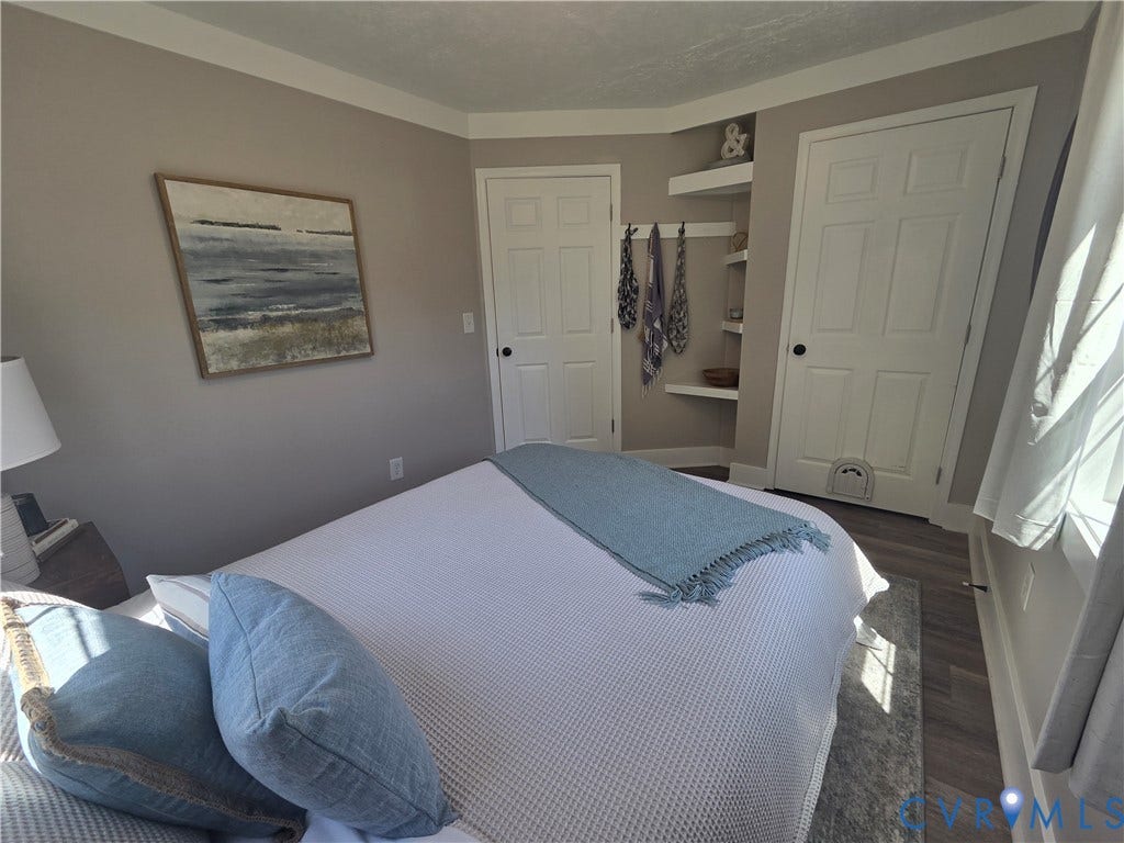 7620 Cypress Drive, Lanexa, VA 23089 Neutral-toned walls paired with wood-finish flooring, featuring dual paneled interior doors and built-in corner shelving